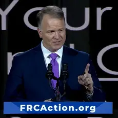 Center for Judicial Renewal's Phillip Jauregui speaks on stage at Pray Vote Stand conference at lectern that has placard reading "FRCAction.org"