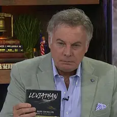 Lance Wallnau seated at a desk in front of a bookshelf, holding a CD he is promoting with LEVIATHAN visible on the label.