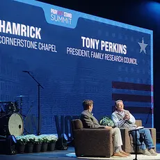 Cornerstone Chapel pastor Gary Hamrick and FRC President Tony Perkins sit on stage at the 2026 Pray Vote Stand summit with their names and IDs projected on the backdrop behind them.