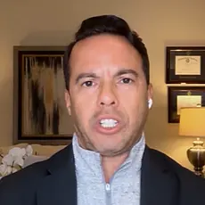 Samuel Rodriguez speaking into the camera in what appears to be a living room or home office setting.