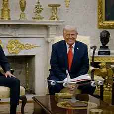 Photo shows US President Donald Trump and President Bukele of El Salvador smiling while seated together in the Oval Office with VP J.D. Vance seated to the side.