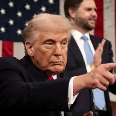 Image of Trump at State of the Union pointing toward audience, with VP JD Vance visible standing behind him and applauding