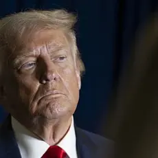 Photo of Trump gazing off camera, possibly listening to someone or assessing something he is looking at