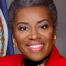 Close crop of official portrait of Virginia Lt. Gov. Winsome Earle-Sears, a black woman wearing a bright red suit jacket, with a Virginia flag visible over her right shoulder. 