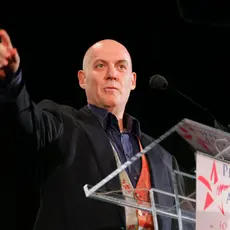 Howie Klein standing behind a podium 