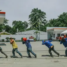 A group of five workers pull a rope
