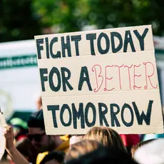 Protesters holding a sign that reads "fight today for a better tomorrow"