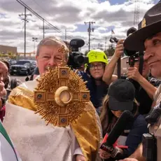 A member of Illinois State Police relays the message to priests that ICE denied them access to detainees to provide them communion, outside a U.S. Immigration and Customs Enforcement facility in Broadview, Ill., Saturday, Oct. 11, 2025. (AP Photo/Adam Gray)