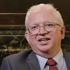 Image of John Eastman, white-haired white man in suit and tie.