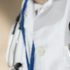 Close up of a doctor's stethoscope and pocket full of pens and pen lights