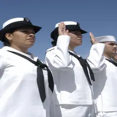 A line of Navy sailors take an oath.