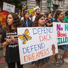 Activists hold signs saying "DACA = Life," "Defend DACA, Defend Dreamers," and "No Human Being Is Illegal" at a DACA rally.