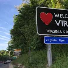 A highway sign reading "Welcome to Virginia, Virginia is for lovers."