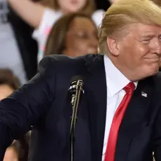 Donald Trump smiles in front of a podium