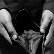 A person holds open an empty wallet