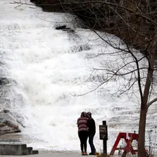 A couple kisses as water gushes down a waterfall at Buttermilk Falls State Park, Monday, Oct. 30, 2017, in Ithaca, N.Y. (AP Photo/Julio Cortez)
