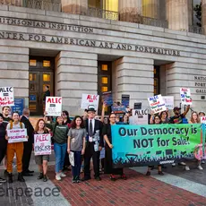 A group of people protest outside ALEC's 50th anniversary event.